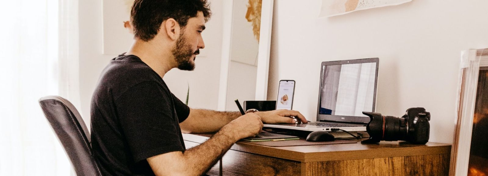 Jongen achter bureau met tekentablet en computer